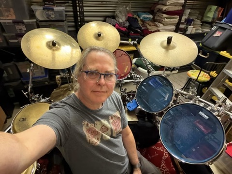 Whit standing beside his drum kit