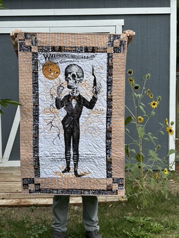 Halloween wall hanging by Michele Urbany Neely Puluti featuring a skeletal figure, pumpkin, spiderwebs, and vintage orange-and-black borders