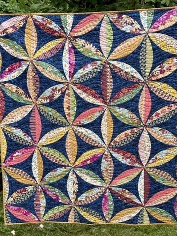 Bright Flowers quilt by Michele Urbany Neely Puluti, featuring colorful curved floral forms against a deep blue background