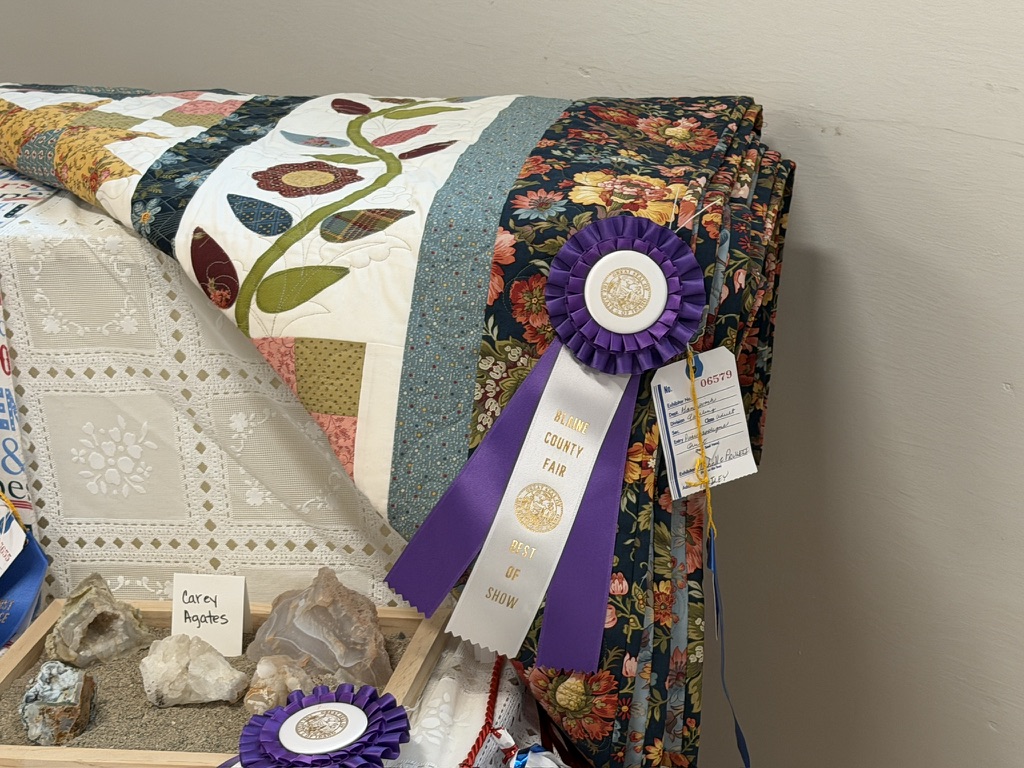 Best of Show ribbon displayed on Michele’s The Farmer’s Daughter quilt at the 2026 Blaine County Fair